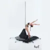 A female pole dancer is getting ready to use her free online pole dance lessons with her Lupit freestanding portable stage base platform dance pole