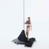 A female pole dancer is standing on her Lupit freestanding portable stage base platform dance pole and its carrying bag